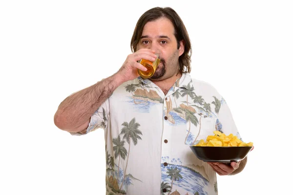 Fat Caucasian man drinking beer and holding bowl of chips ready — Stock Photo, Image