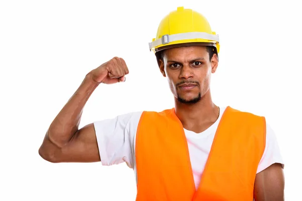 Jovem homem africano trabalhador da construção flexionando o braço — Fotografia de Stock