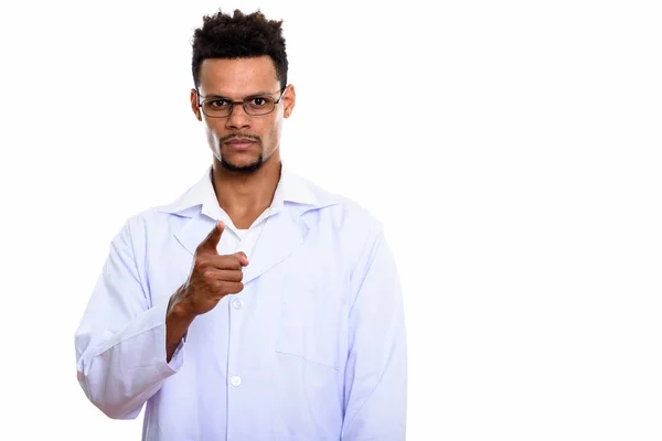 Studio shot of young African man doctor pointing at camera — Stock Photo, Image