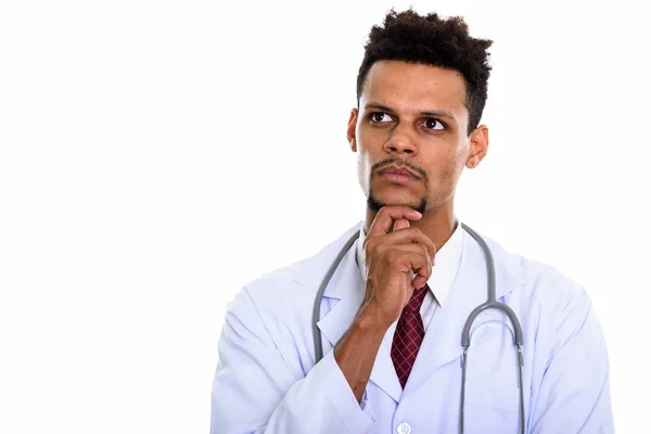 Studio shot of young African man doctor thinking while looking u — Stock Photo, Image
