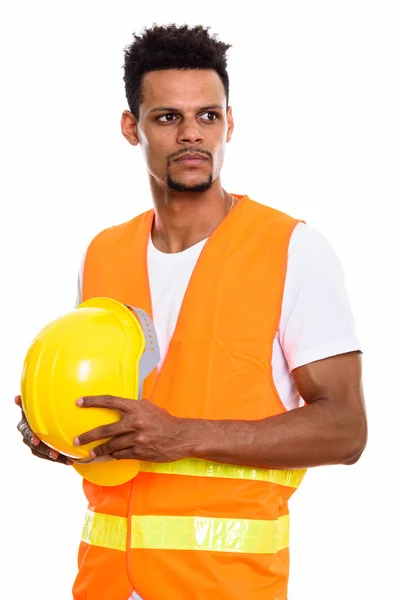 Joven africano trabajador de la construcción sosteniendo casco de seguridad mientras —  Fotos de Stock