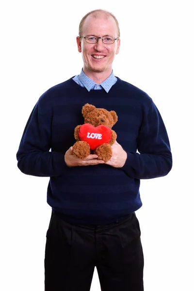 Feliz hombre sonriendo mientras sostiene oso de peluche con el corazón y el amor s —  Fotos de Stock