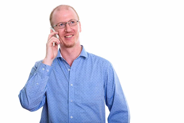 Задумчивый счастливый бизнесмен улыбается во время разговора на мобильном телефоне — стоковое фото