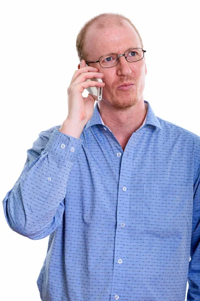 Studio shot of businessman talking on mobile phone while thinkin — Stock Photo, Image