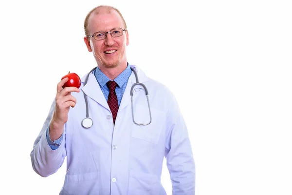 Studio strzał szczęśliwy człowiek lekarz uśmiecha się trzymając czerwone jabłko — Zdjęcie stockowe