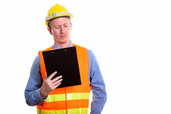 Estudio plano de hombre trabajador de la construcción leyendo en portapapeles —  Fotos de Stock