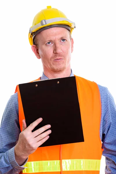Estúdio tiro de homem trabalhador da construção segurando prancheta enquanto t — Fotografia de Stock