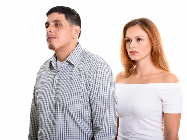 Estúdio tiro de jovem casal pensando enquanto olha para longe juntos — Fotografia de Stock