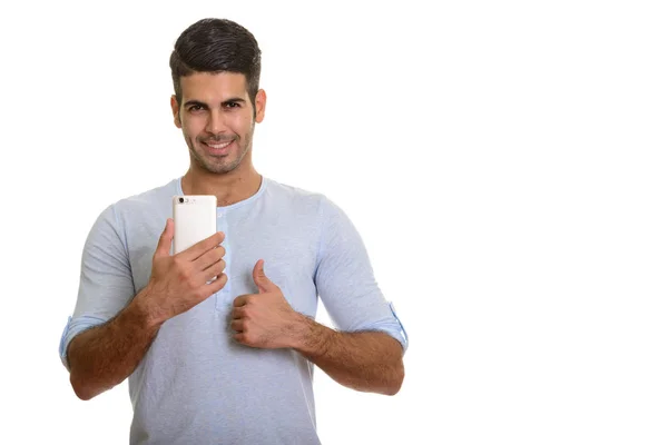 Giovane felice uomo persiano sorridente mentre tiene il telefono cellulare e g — Foto Stock