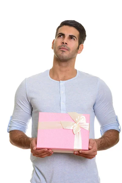 Young handsome Persian man holding gift box while thinking — Stock Photo, Image