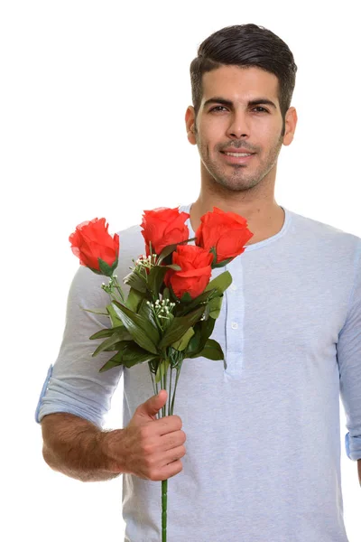 Jovem feliz persa homem sorrindo enquanto segurando rosas vermelhas pronto fo — Fotografia de Stock