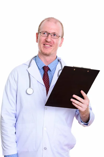 Studio shot of happy man doctor smiling while holding clipboard Stock Image