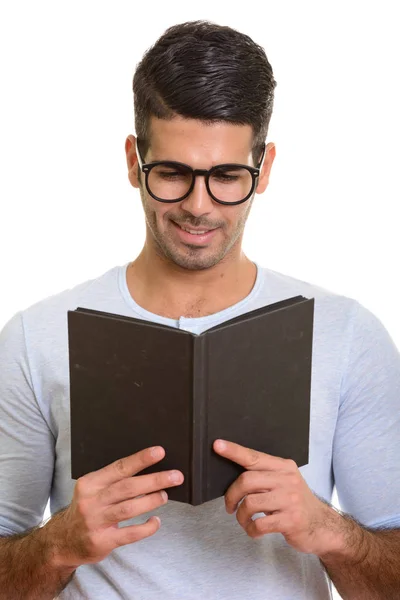 Joven hombre persa feliz sonriendo mientras lee libro —  Fotos de Stock