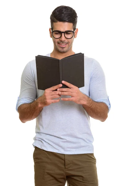 Jong gelukkig Perzische man glimlachend tijdens het lezen boek — Stockfoto