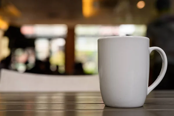 Cangkir kopi dengan rokok di atas meja kayu di restoran dengan ou — Stok Foto