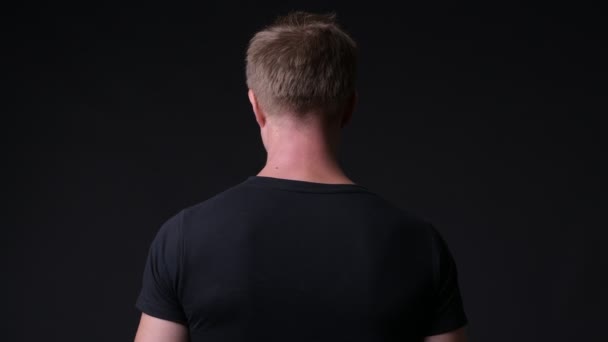 Junger schöner Mann vor schwarzem Hintergrund — Stockvideo