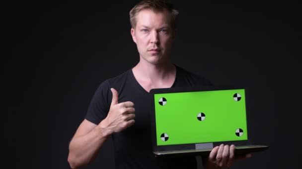 Молодий красивий чоловік використовує ноутбук з зеленим екраном хром ключ — стокове відео