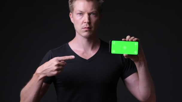 Jeune homme beau en utilisant un téléphone mobile avec écran vert chroma clé — Video