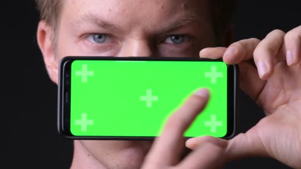 Młody przystojny mężczyzna przy użyciu telefonu komórkowego z zielony ekran chroma key — Wideo stockowe