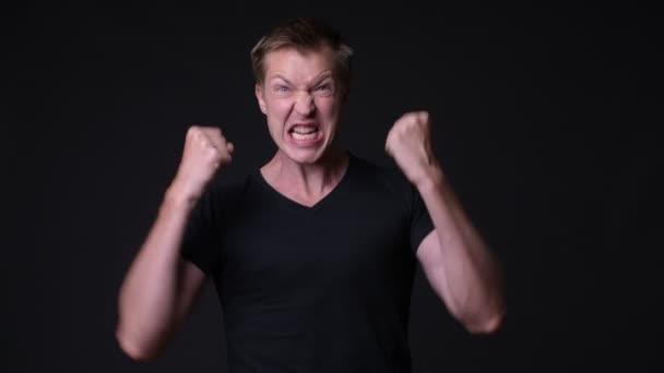 Young handsome man against black background — Stock Video