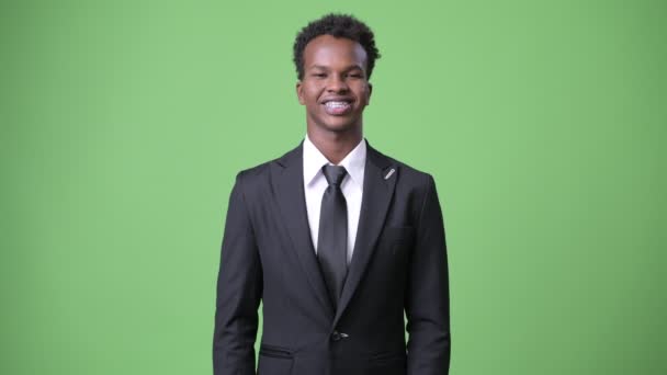 Young African businessman against green background — Stock Video