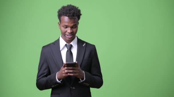Jonge Afrikaanse zakenman tegen groene achtergrond — Stockvideo