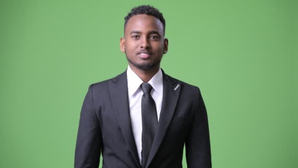 Jeune homme d'affaires africain beau sur fond vert — Video