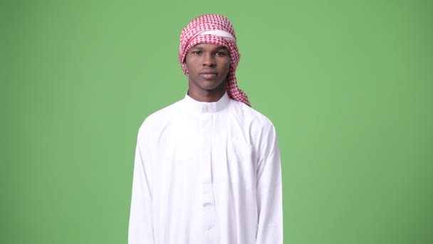 Jeune homme africain portant des vêtements musulmans traditionnels sur fond vert — Video