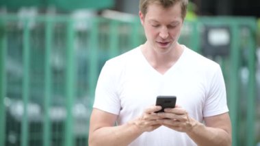 Yakışıklı delikanlı sokaklarda açık havada istimal hareket eden telefon