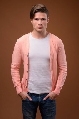 Yakışıklı delikanlı kahverengi arka plan stüdyo çekim