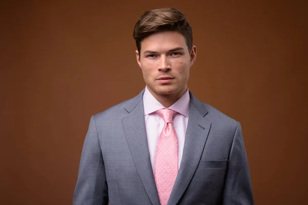 Studio shot of young handsome businessman in suit — Stock Photo, Image