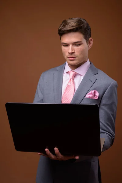 Studio shot of young handsome businessman in suit — Stock Photo, Image