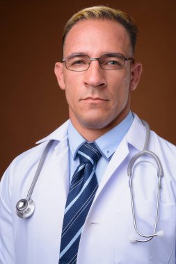 Kahverengi arka planı olan bir adamın yüzü.