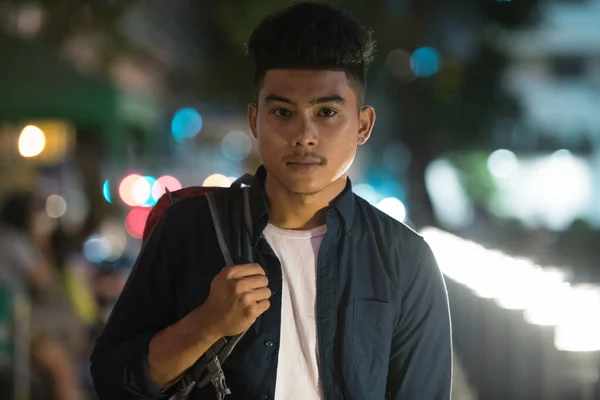 Fiatal ázsiai férfi a város utcáin éjszaka — Stock Fotó