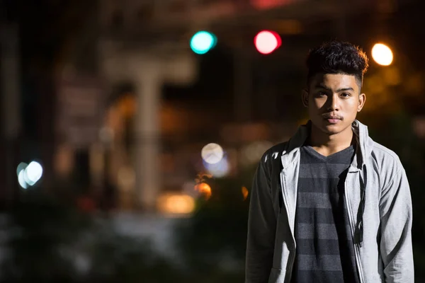 Молодий азіат на вулицях міста вночі. — стокове фото