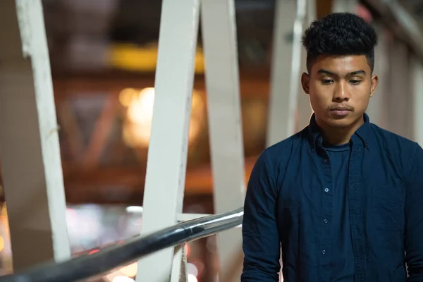 夜には歩道橋を見下ろしながら、若いアジアの男の思考をストレス — ストック写真