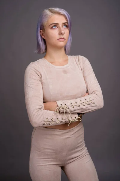 Junge schöne Rebellin mit buntem Haar gegen grauen Rücken — Stockfoto