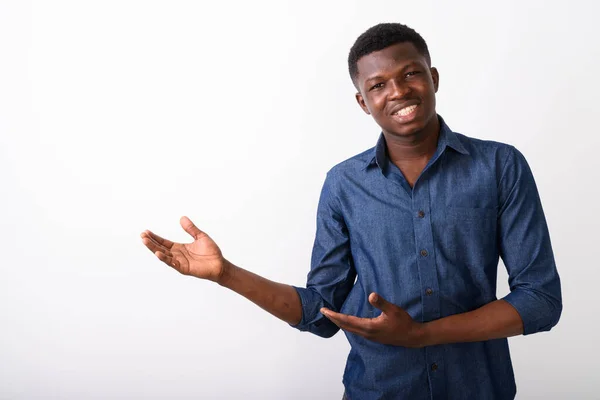 Studio shot of young happy black African man smiling while showi — Stock Photo, Image