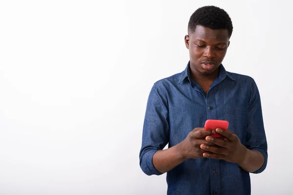 Estudio de disparo de joven negro africano hombre usando el teléfono móvil de nuevo —  Fotos de Stock