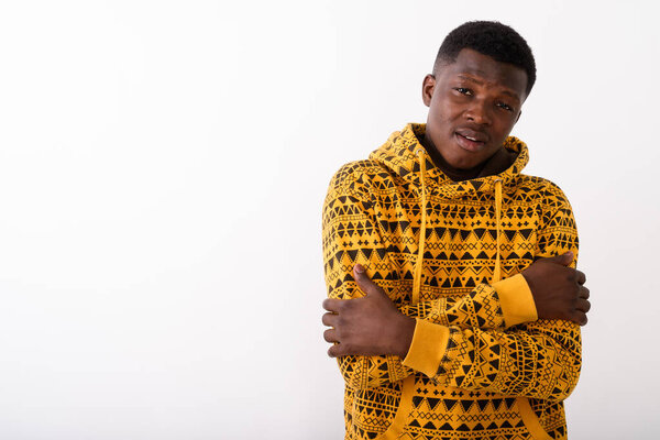 Studio shot of young black African man feeling cold against white background