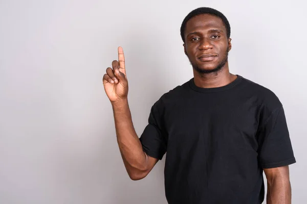 Mladí africké muž na sobě černé tričko šedé pozadí — Stock fotografie