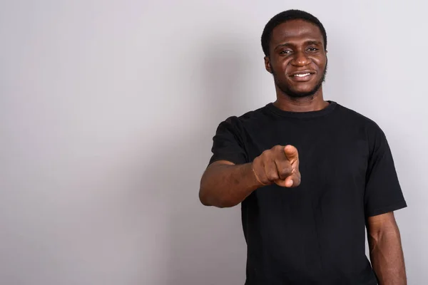 Joven hombre africano con camisa negra sobre fondo gris —  Fotos de Stock