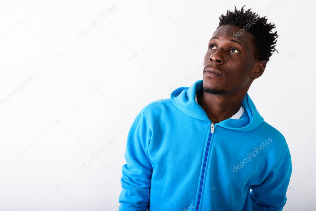 Close up of young black African man thinking while looking up ag