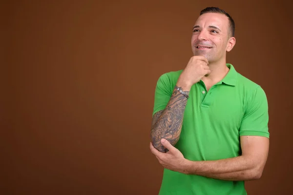 Hombre vistiendo camisa verde sobre fondo marrón —  Fotos de Stock