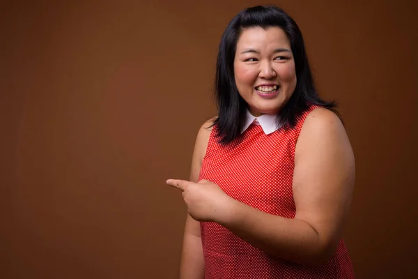Beautiful overweight woman laughing and pointing finger to copy space — 스톡 사진