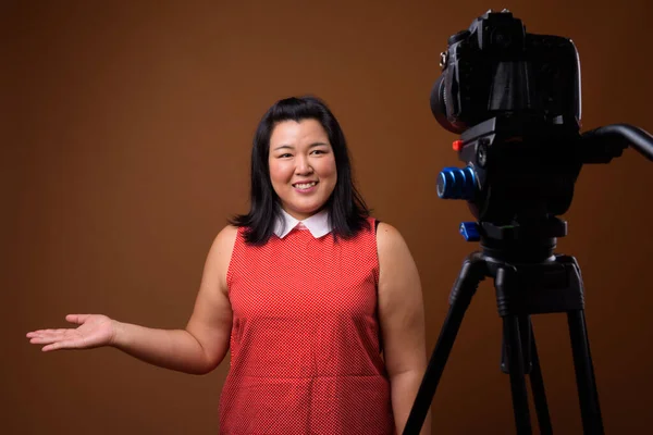 Sobrepeso asiático mujer vlogging en estudio con dslr cámara en trípode —  Fotos de Stock