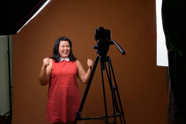 Sobrepeso asiático mujer vlogging en estudio con dslr cámara en trípode —  Fotos de Stock
