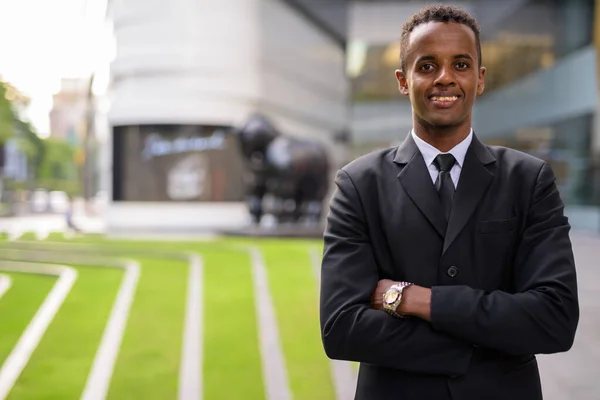 Επιτυχημένος νεαρός Αφρικανός επιχειρηματίας χαμογελώντας έξω με σταυρωμένα χέρια — Φωτογραφία Αρχείου