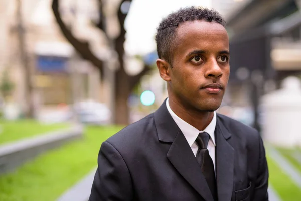 都市の屋外で考える若いアフリカのビジネスマンの顔 — ストック写真