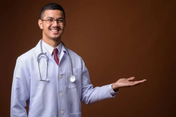 Giovane multi-etnico asiatico uomo medico contro marrone sfondo — Foto Stock